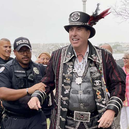 Policeman holding arm of man dressed as a pirate captain